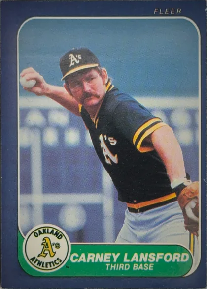 Front of 1986 Fleer Baseball Cards Carney Lansford #426 Base, front of a baseball card. A dark blue border surrounds a rounded-corner color photograph of a mustached player in a black Oakland Athletics jersey…