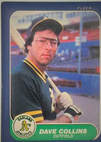 Front of 1986 Fleer Baseball Cards Dave Collins #415 Base, portrait baseball card front. A player in an Oakland Athletics uniform and batting helmet is shown holding a bat in a stadium. The card has a dark…