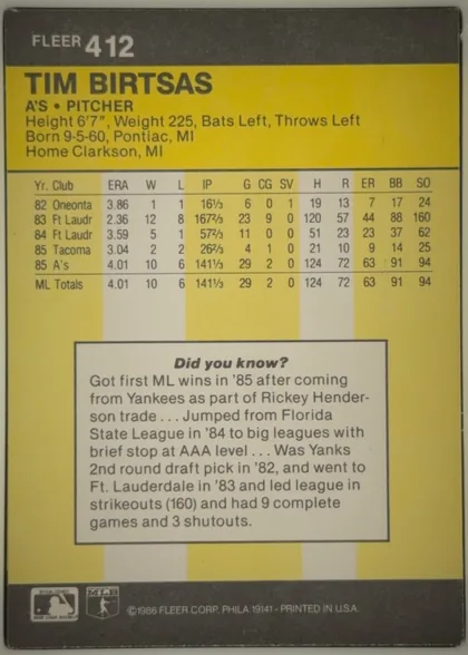 Back of 1986 Fleer Baseball Cards Tim Birtsas #412, back of a portrait-oriented baseball card. A dark charcoal-gray header contains the white FLEER brand and card number 412 at upper left. Below it, a…