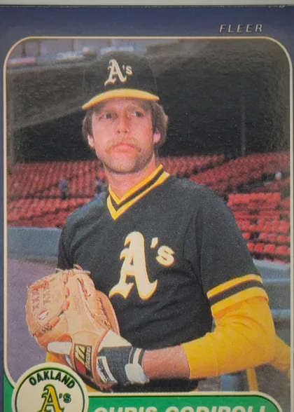 Front of 1986 Fleer Chris Codiroli #414, upright portrait baseball card front. A color photograph shows an Oakland A's player in a black-and-yellow uniform and cap, holding a glove. FLEER…