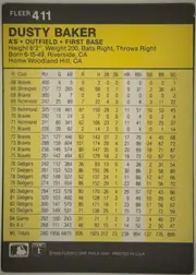 Back of 1986 Fleer Dusty Baker #411 Base, landscape-oriented statistics back with a black header bearing FLEER and card number 411 at upper left. A yellow title panel contains the large bold…
