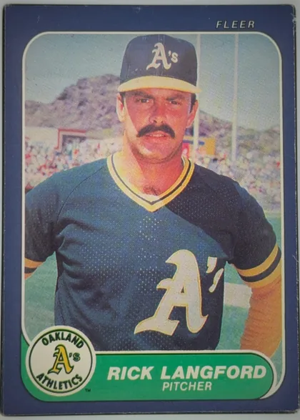 Front of 1986 Fleer RICK LANGFORD #425 Base, portrait baseball card front. A centered color photograph shows Rick Langford in an Oakland Athletics uniform and cap. The top navy border carries…