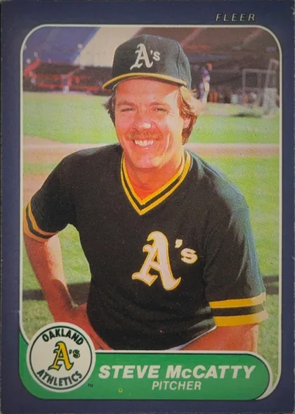Front of 1986 Fleer STEVE McCATTY #427 Base, portrait-oriented baseball card front showing Steve McCatty in an Oakland A's uniform and cap, posed on a baseball field. The photograph occupies…