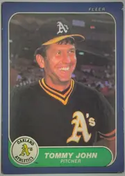 Front of 1986 Fleer Tommy John #422, upright portrait-format baseball card front. A color photograph shows Tommy John in an Oakland Athletics uniform and cap, centered against a stadium…