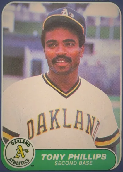 Front of 1986 Fleer Tony Phillips #430 Base, front of a baseball card. A color head-and-shoulders portrait of a player wearing an Oakland Athletics home uniform: white jersey with arched…
