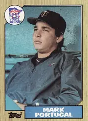 Front of 1987 Topps Mark Portugal #419 Base, upright portrait baseball card showing a player in a dark Minnesota Twins cap and jacket against a blue stadium background. A circular Win! Twins!…