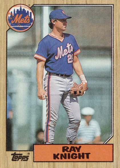Front of 1987 Topps Ray Knight #488 Base, portrait baseball card front. A full-body photograph of a New York Mets player in a blue uniform occupies the central image area. The circular Mets…