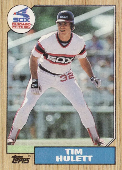 Front of 1987 Topps Tim Hulett #566 Base, portrait baseball card front. A player in a white Chicago White Sox uniform is shown in an action pose against a stadium background. The circular…