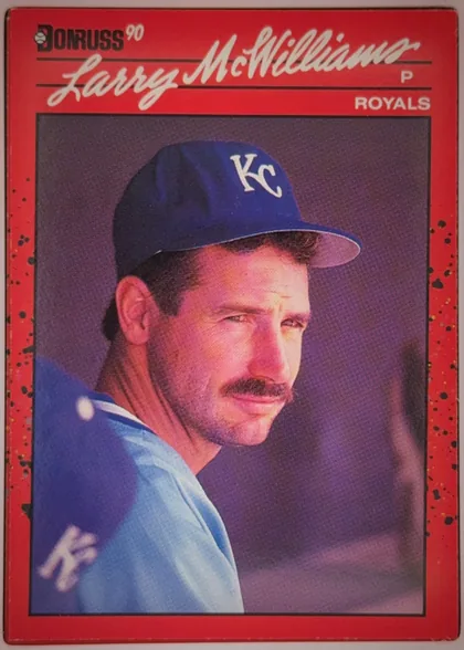 Front of 1989 Donruss Baseball LARRY DEAN McWILLIAMS #709, portrait baseball card front oriented upright. A red, black-speckled border surrounds a large color portrait of Larry McWilliams wearing a Kansas…