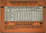 Back of 1990 Donruss Baseball Bob McClure #470 Base, orange baseball card back oriented upright, with a circular baseball graphic and card number 470 at upper left. The player's name is printed…