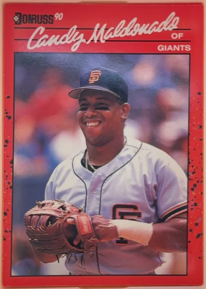 Front of 1990 Donruss Baseball Candy Maldonado #611, portrait baseball card front. A red dotted border surrounds a large photograph of Candy Maldonado in a Giants uniform holding a glove. The Donruss…
