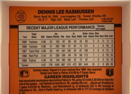 Back of 1990 Donruss Baseball Dennis Lee Rasmussen #420, upright landscape-oriented card back dominated by an orange field. The player name is centered across the top in bold black type, with biographical…