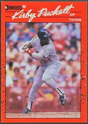 Front of 1990 Donruss Baseball Kirby Puckett #269 Base, portrait baseball card front. A bright red border surrounds a full-color action photograph of Kirby Puckett batting in a Minnesota Twins uniform…