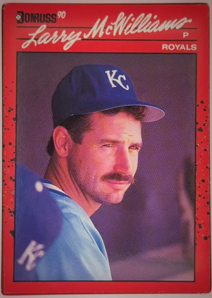Front of 1990 Donruss Baseball Larry McWilliams #709 Base, upright portrait-format baseball card front. A red border surrounds a large color portrait of Larry McWilliams in a Kansas City Royals uniform and…