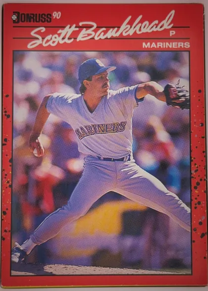 Front of 1990 Donruss Baseball Michael Scott Bankhead #261, portrait-oriented baseball card front. A red header and border surround a large action photograph of a Mariners pitcher in a white uniform…