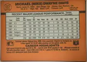 Back of 1990 Donruss Baseball Mike Davis #552, upright landscape-oriented baseball card back dominated by an orange field. The upper area has the player name in large black type, with card number…