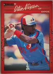 Front of 1990 Donruss Baseball Otis Nixon #456, portrait baseball card front. A red border surrounds a large action photograph of a baseball player in a blue, red, and white Expos uniform swinging…