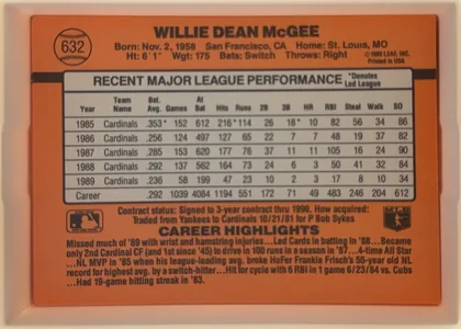 Back of 1990 Donruss Baseball Willie McGee #632, upright landscape-oriented baseball card back. An orange background fills the card, crossed by a black horizontal stripe. The upper portion…