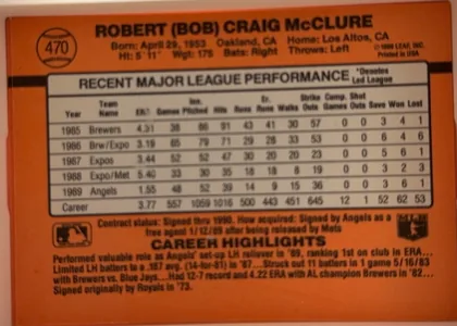Back of 1990 Donruss Bob McClure #470, landscape-oriented baseball card back on a solid orange field. Upper left holds a black baseball-outline graphic containing the number 470. Across…