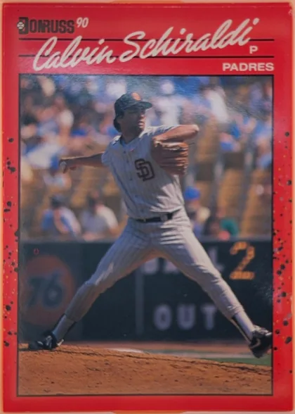 Front of 1990 Donruss Calvin Schiraldi #672, portrait-oriented baseball card front. A red header and border surround a large action photograph of a Padres player pitching. The Donruss logo and…