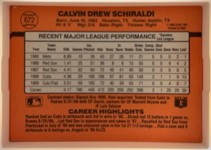Back of 1990 Donruss Calvin Schiraldi #672, upright baseball-card back dominated by an orange-red field. The player name is centered across the top, with biographical details beneath it. A…