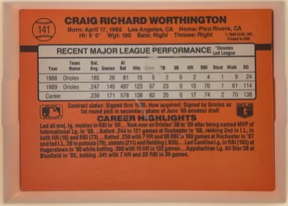 Back of 1990 Donruss Craig Worthington #141, landscape-oriented orange-red baseball card back. The player name appears prominently across the upper portion, with a baseball-shaped number emblem…