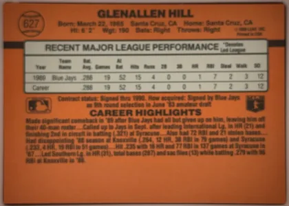 Back of 1990 Donruss Glenallen Hill #627, landscape-oriented orange baseball card back. The player name is centered across the top, with card number 627 in a circular baseball graphic at…