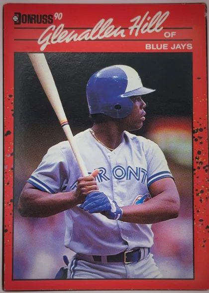 Front of 1990 Donruss Glenallen Hill #627, portrait baseball card front. A red border surrounds a large color photograph of a Blue Jays batter holding a bat. The Donruss logo and "'90" appear…