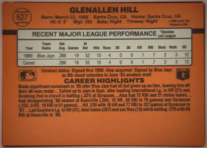 Back of 1990 Donruss Glenallen Hill #627, landscape-oriented baseball card back dominated by an orange-brown background. The player name Glenallen Hill is centered across the top, with…