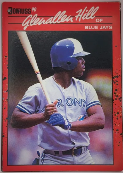 Front of 1990 Donruss Glenallen Hill #627, portrait baseball card front. A large color photograph shows a Toronto Blue Jays batter in uniform and helmet holding a bat. The upper red header…