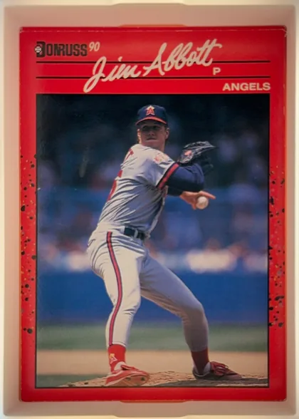 Front of 1990 Donruss Jim Abbott #108, portrait baseball card front. A large color photograph shows a pitcher in an Angels uniform delivering a pitch. The red header contains the Donruss…