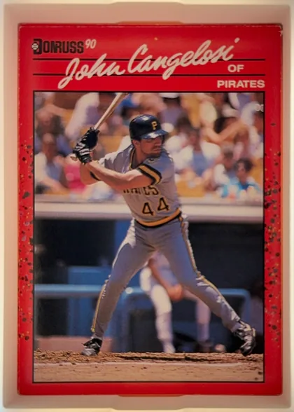 Front of 1990 Donruss John Cangelosi #565, portrait-oriented baseball card front. A red title panel at the top contains the Donruss logo and "'90" at upper left, the large cream script name…