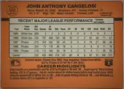 Back of 1990 Donruss John Cangelosi #565 Base, landscape-oriented baseball card back. An orange/brown field surrounds a large cream statistics table centered across the upper and middle area. The…