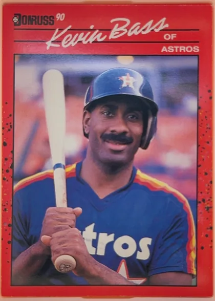 Front of 1990 Donruss Kevin Bass #589, portrait baseball card front. A red border surrounds a large color photograph of Kevin Bass holding a bat in an Astros uniform and helmet. The…