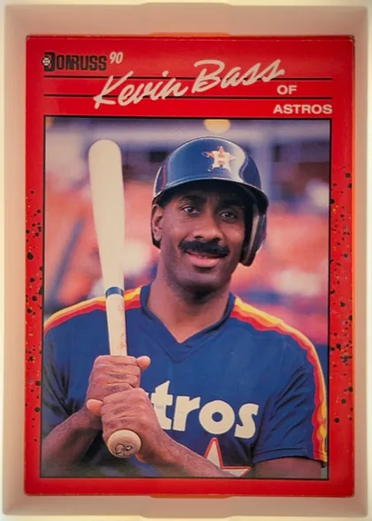 Front of 1990 Donruss Kevin Bass #589, portrait-oriented baseball card front. The upper section has a red header with the Donruss logo and "90" at upper left, a large white script player…
