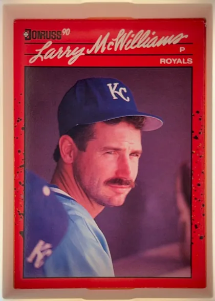 Front of 1990 Donruss Larry McWilliams #709, portrait baseball card with a red border and black speckled side accents. The DONRUSS 90 logo is at the upper left. Larry McWilliams appears in…
