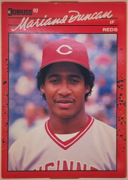 Front of 1990 Donruss Mariano Duncan #684, portrait-oriented baseball card front. A red speckled border surrounds a large centered portrait of Mariano Duncan in a Cincinnati Reds uniform. The…