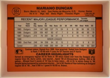 Back of 1990 Donruss Mariano Duncan #684, upright landscape-format baseball card back dominated by a bright orange field. A black stripe runs horizontally behind a large white…