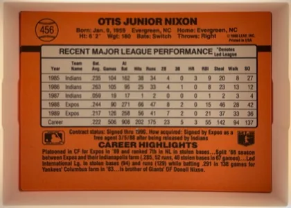 Back of 1990 Donruss Otis Nixon #456, upright landscape-oriented baseball card back. The orange-red background carries a large black horizontal stripe behind a centered light gray…