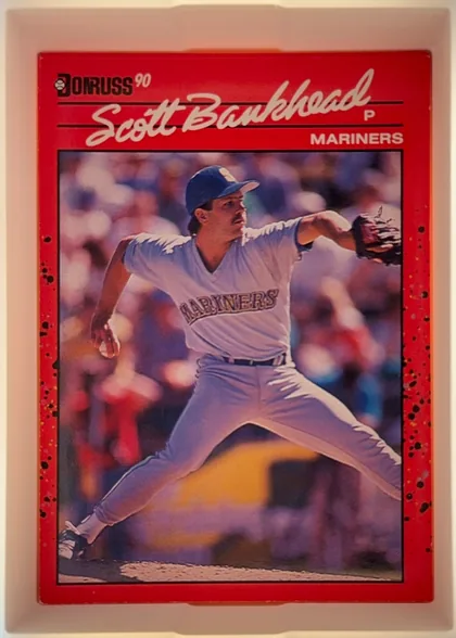 Front of 1990 Donruss Scott Bankhead #261, portrait baseball card front. The upper area has a bright red background, the Donruss logo at upper left, large cream script reading Scott Bankhead…
