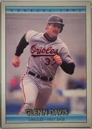 Front of 1991 Donruss Baseball Cards Mickey Tettleton #597, portrait baseball card front. A centered action photograph shows Glenn Davis in a Baltimore Orioles uniform. The top blue gradient band displays…