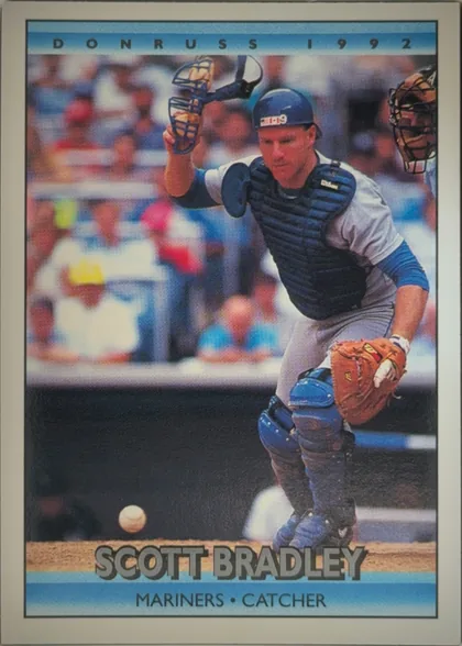 Front of 1992 Donruss Baseball Scott Bradley #713 Base, upright portrait baseball card. The top light-blue band reads DONRUSS 1992. The center shows a catcher in full protective gear crouching behind home…