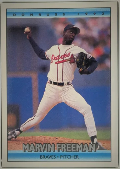 Front of 1992 Donruss Marvin Freeman #603, portrait-oriented baseball card front. A color action photograph shows a pitcher in a white Atlanta Braves uniform delivering a pitch. The top blue…