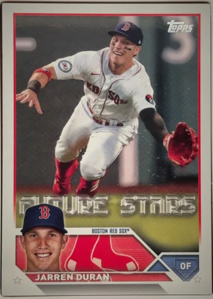 Front of 2023 Topps Jarren Duran #242 Base, portrait baseball card front. A Boston Red Sox player is shown in an action photograph wearing a white uniform and dark cap, reaching with a red…