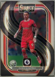 Front of 2024-25 Panini Select Premier League Soccer Darwin Núñez #142 Mezzanine, upright portrait soccer card. A full-body image of Darwin Núñez in a red Liverpool FC kit appears centrally over a dark abstract background with…