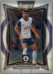 Front of 2024-25 Panini Select Premier League Soccer Dominic Solanke #6 White Ice Prizm /85, upright portrait soccer card featuring Dominic Solanke in a white Tottenham Hotspur jersey, centered in an ornate dark navy, black, gold, and silver…