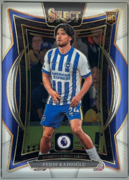 Front of 2024-25 Panini Select Premier League Soccer Ferdi Kadıoğlu #36 Terrace, upright portrait soccer card front. A full-body player in a blue-and-white Brighton & Hove Albion striped kit is centered against a stadium scene…