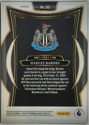 Back of 2024-25 Panini Select Premier League Soccer Harvey Barnes #89, upright portrait-oriented card back. A white border surrounds a black panel framed by thin gold lines and curved gold-and-white decorative elements…