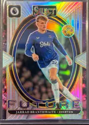Front of 2024-25 Panini Select Premier League Soccer Jarrad Branthwaite #12 Select Future Prizm, front side. A vertical oval/egg-shaped central window holds a full-body action photo of a blond player in a blue Everton home kit: long-sleeve blue…