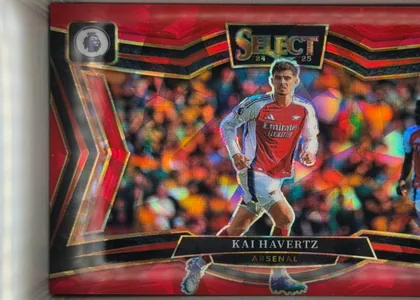 Front of 2024-25 Panini Select Premier League Soccer Kai Havertz #202 Field Level, front of a portrait-oriented football card with a red, black, and gold geometric design. A Premier League lion logo appears in the upper-left…